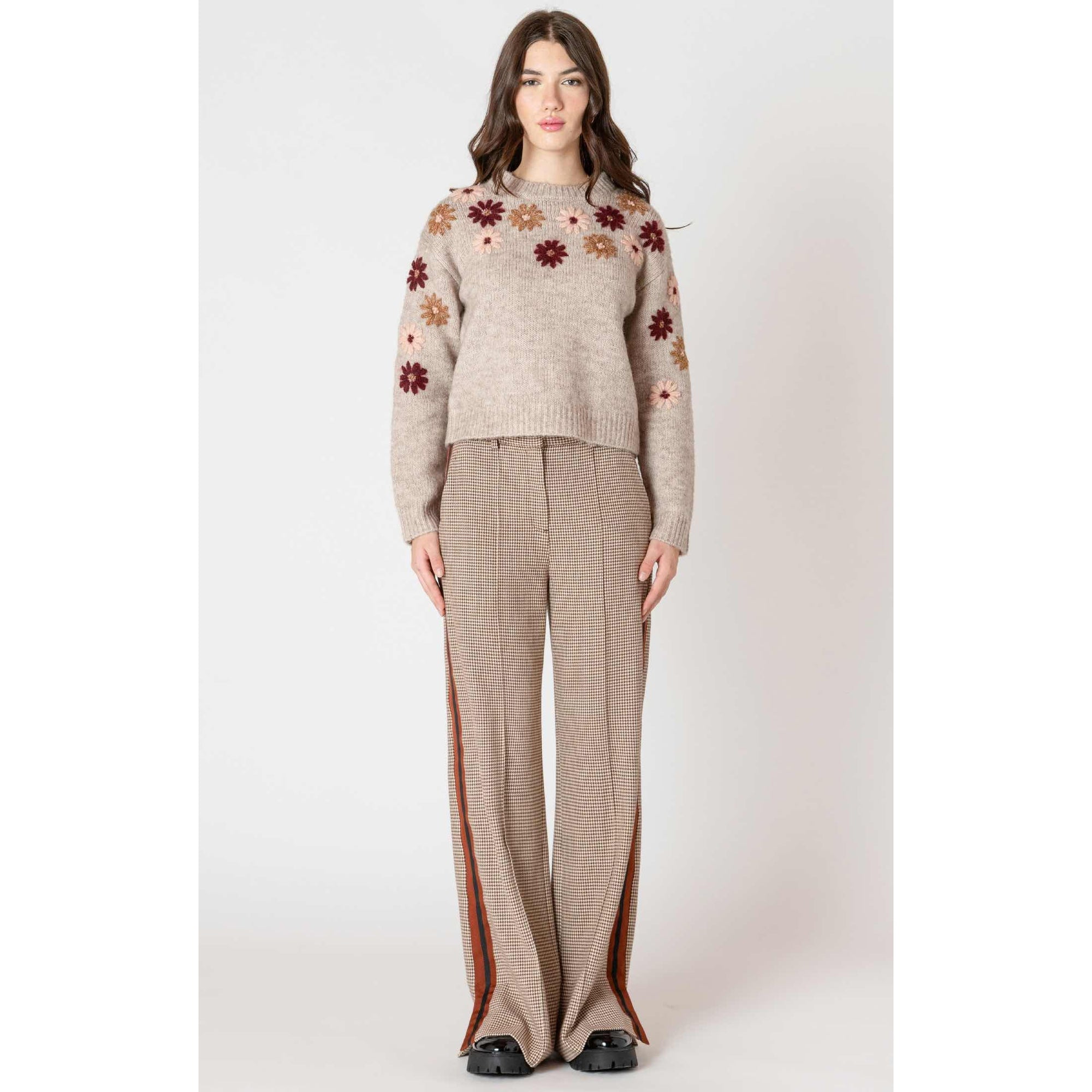 Dex Black Tape Floral Applique Crew Sweater on model with beige knit and floral appliques.