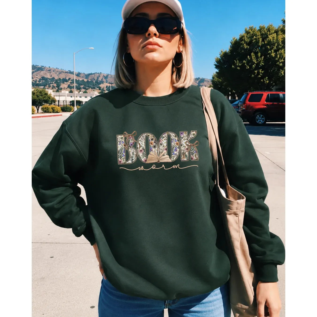 Green vintage inspired 3 Book Worm Classic Crew sweatshirt with floral and book graphic worn by a woman outdoors