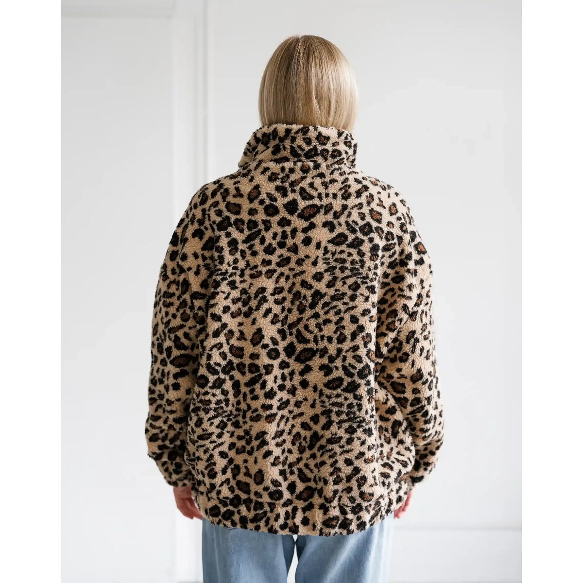 Back view of a relaxed fit leopard print sherpa jacket with a high collar and all-over animal pattern.