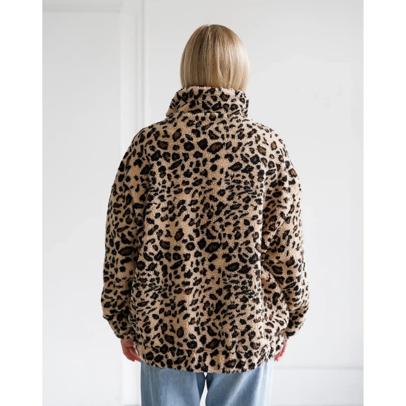 Back view of a relaxed fit leopard print sherpa jacket with a high collar and all-over animal pattern.