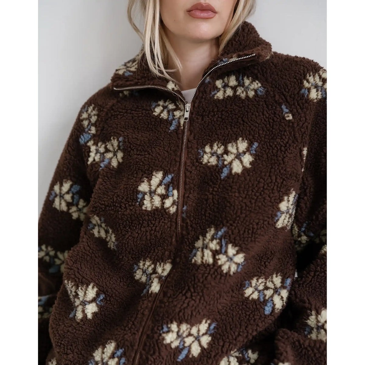 Brown sherpa jacket with cream and blue horse print, featuring a full zip and cozy collar.