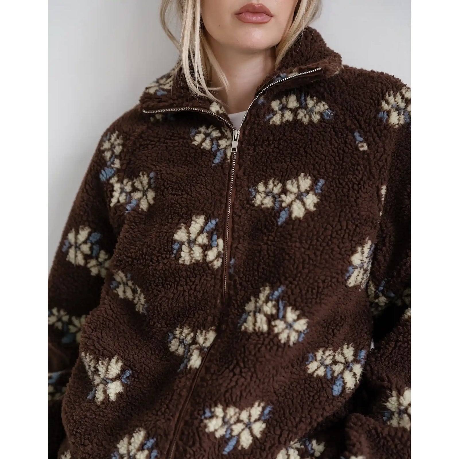 Brown sherpa jacket with cream and blue horse print, featuring a full zip and cozy collar.