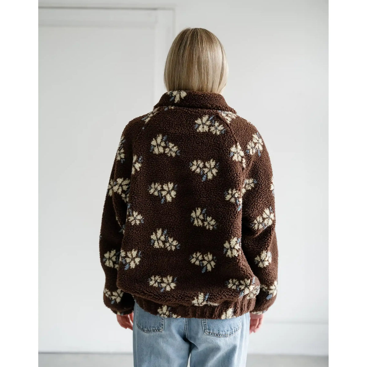 Back view of a brown Sherpa jacket with an all-over cream horse print, featuring a cozy collar and relaxed fit.