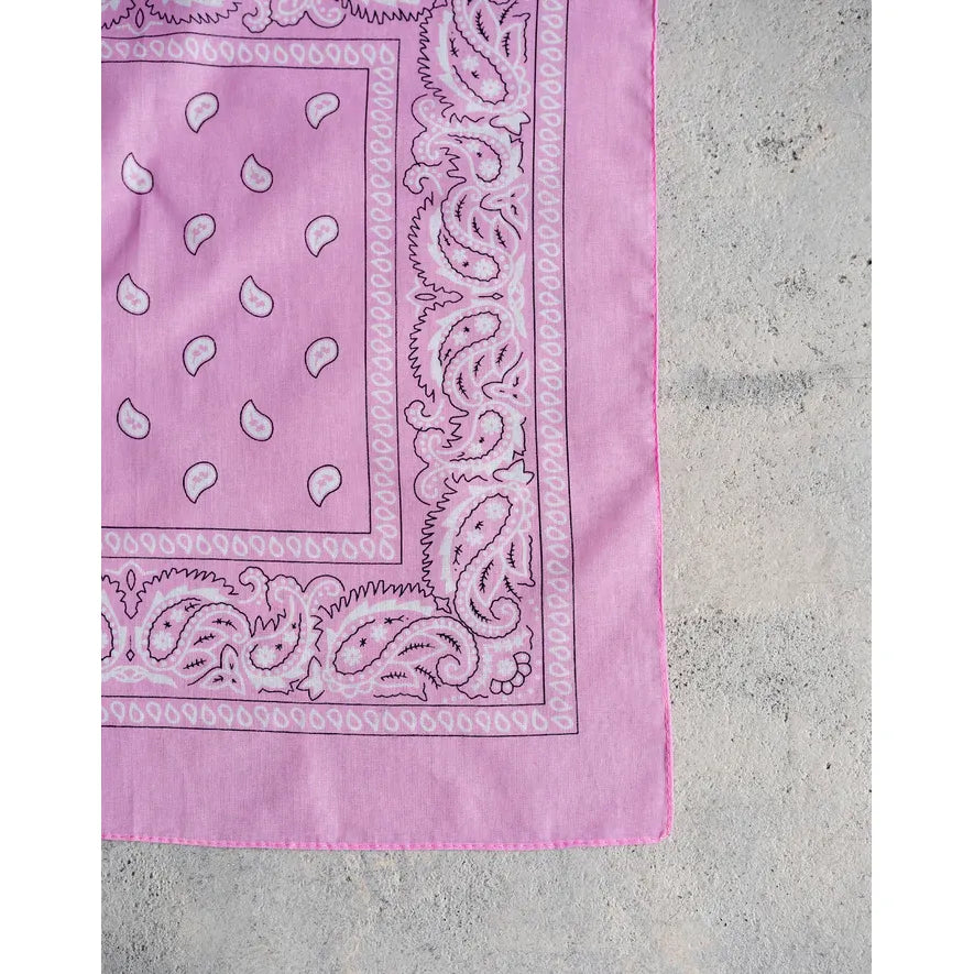 Pink cotton Brunette the Label Western Bandana with white paisley border on concrete.