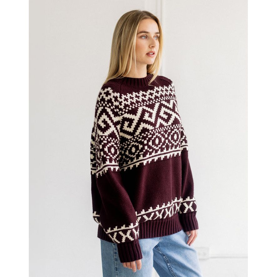 Oversized deep plum Fair Isle knit sweater featuring a bold cream geometric pattern across the chest and cuffs.