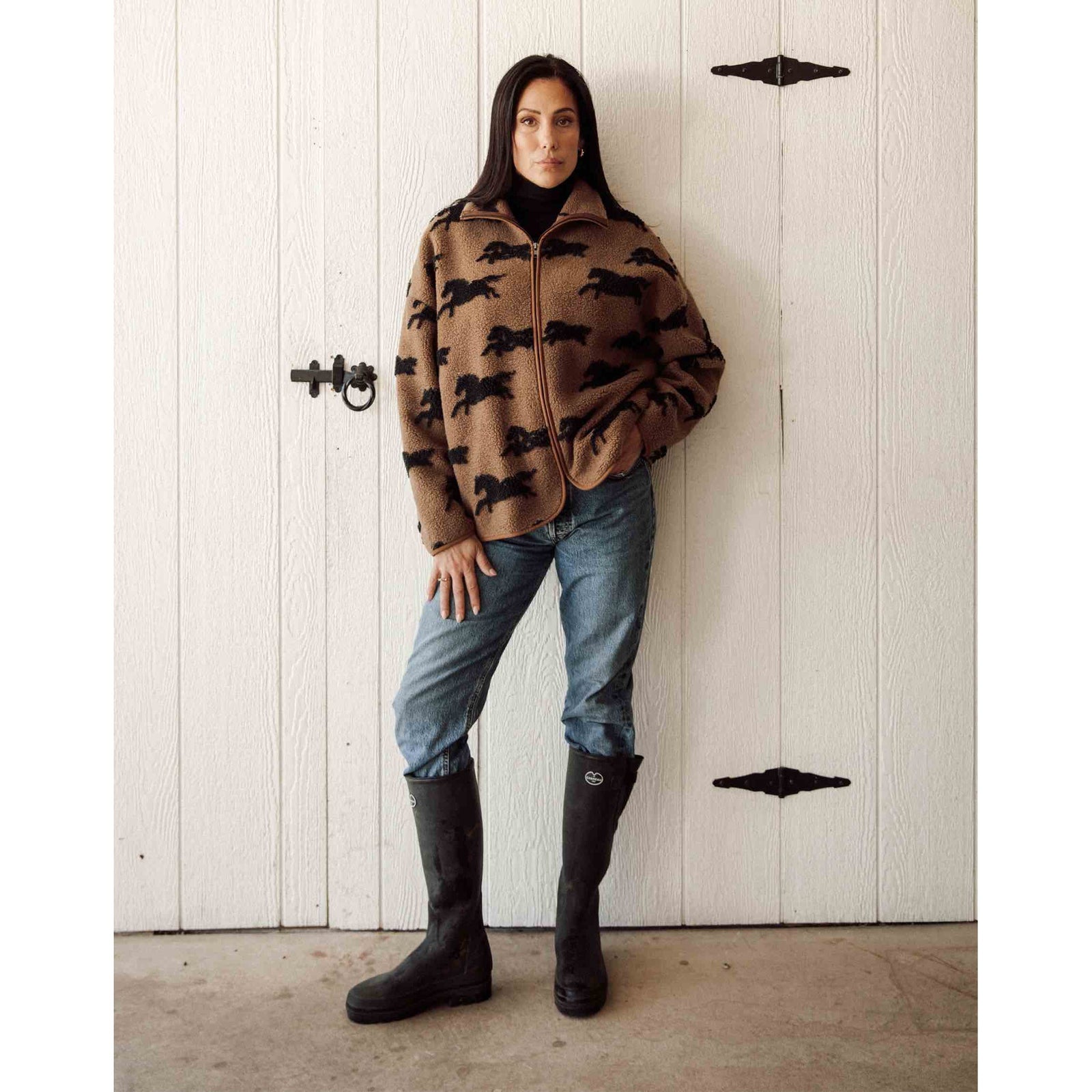 Brunette the Label full-zip horse-print sherpa jacket on model; tan with black horses, cozy collar, paired with jeans.