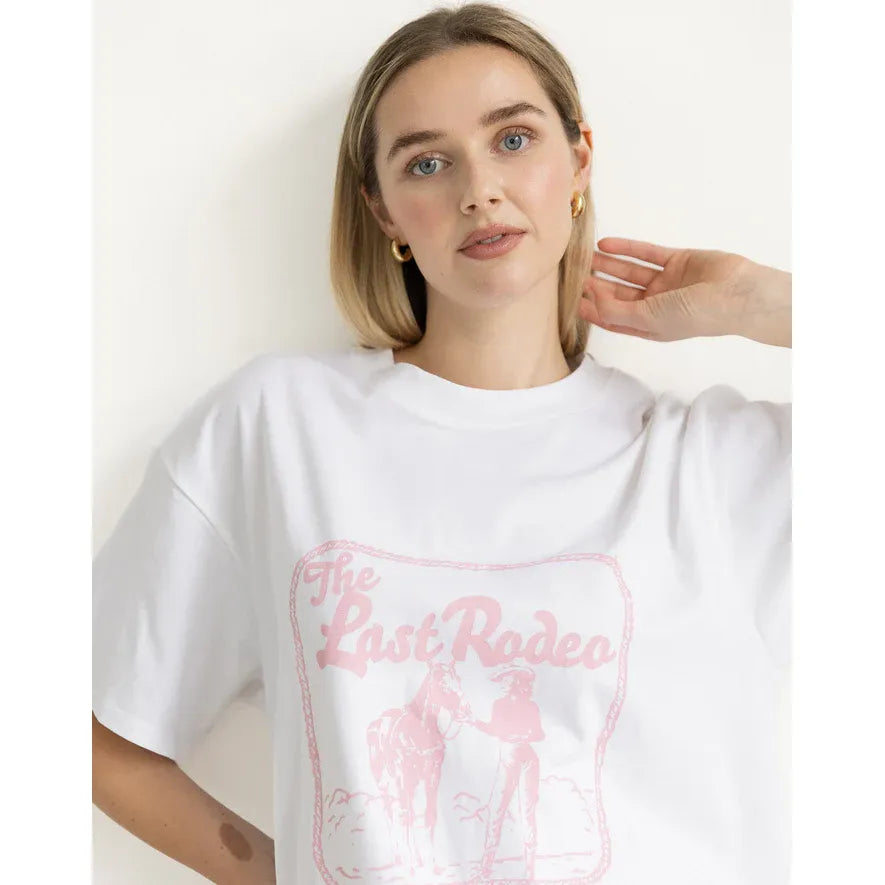 Model wearing Brunette the Label Last Rodeo Boxy Tee; white oversized cotton with pink Last Rodeo graphic.