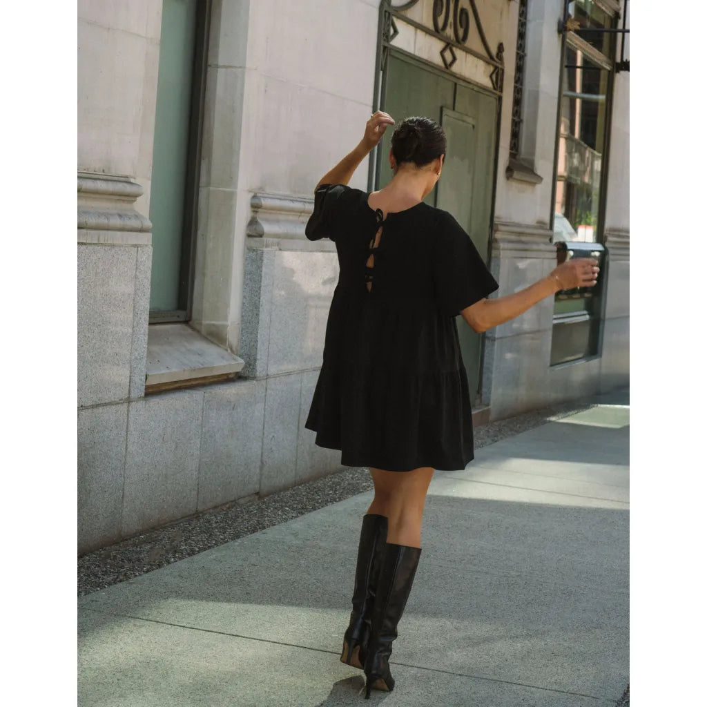 Brunette The Label Tiered Dress in black cotton, oversized knee-length with back bows.