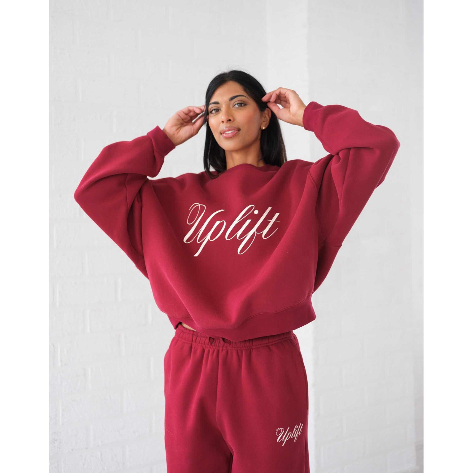 Brunette the Label Uplift Perfect Crew burgundy sweatshirt with white Uplift script and matching joggers.