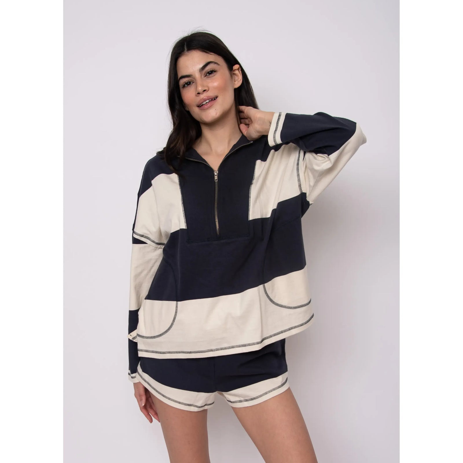 Model wearing Camille Striped 1/2 Zip Rugby Shirt in navy and cream color-block stripes.