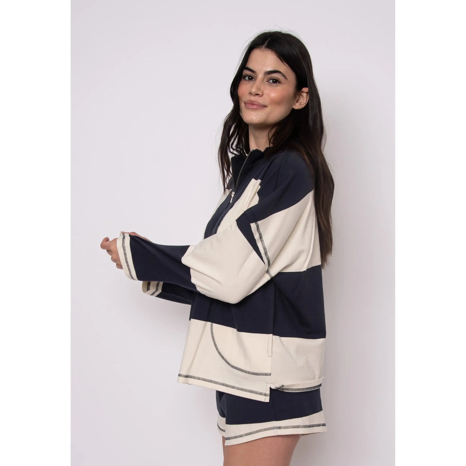 Model wearing Camille Striped 1/2 Zip Rugby Shirt in navy and cream color blocks, long-sleeve.