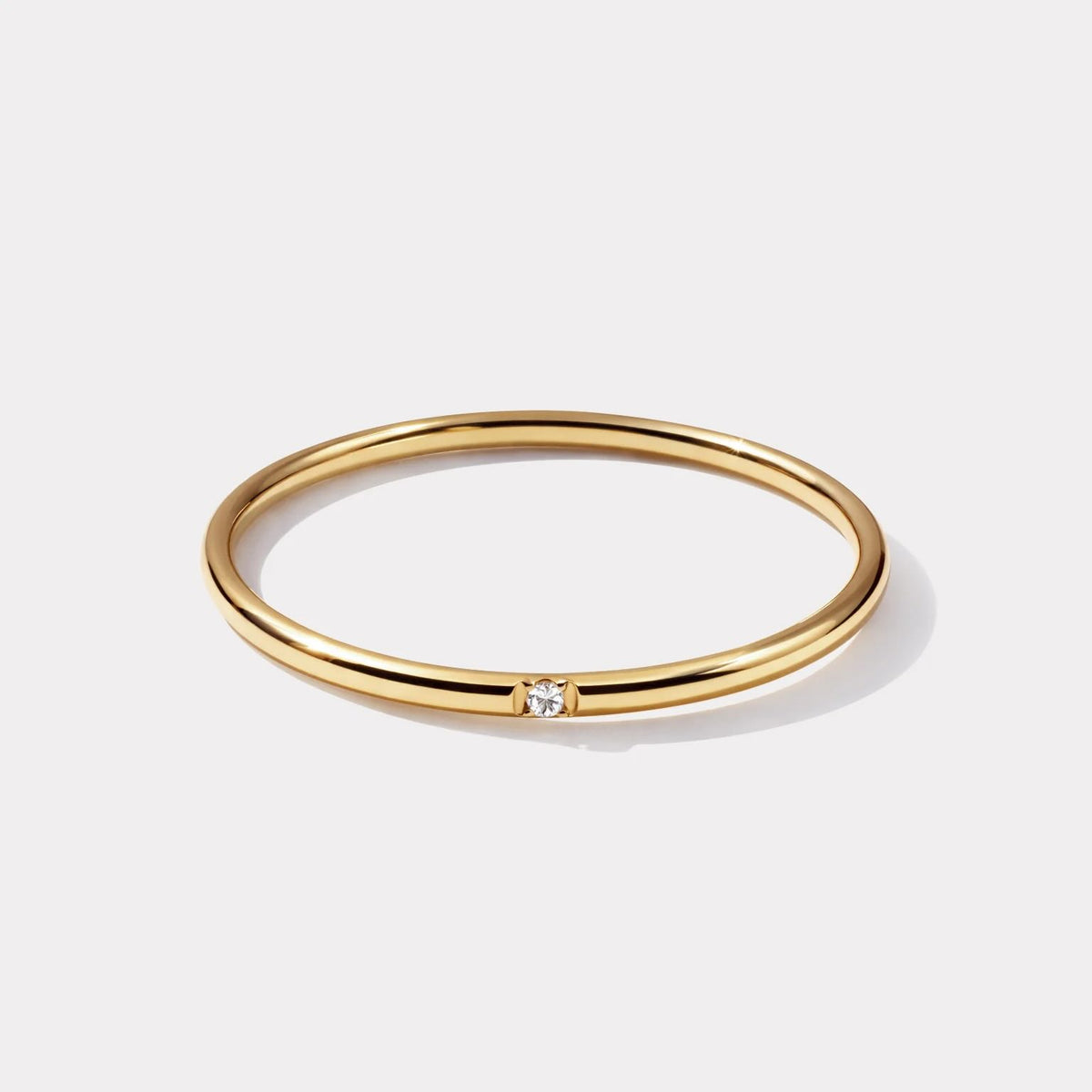 Celeste Gold-Tone Ring: a slim gold-plated stainless steel band with a delicate translucent cubic zirconia centerpiece.