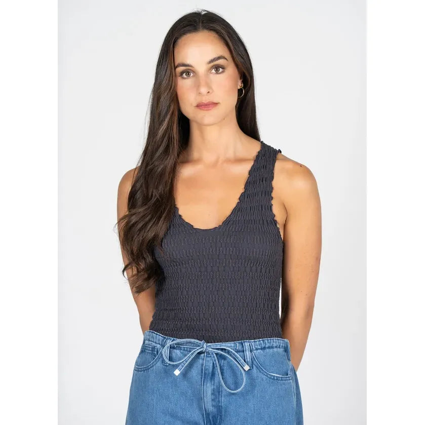 Textured dark grey bamboo smocked V-neck tank top with a contoured silhouette, styled with blue denim jeans.