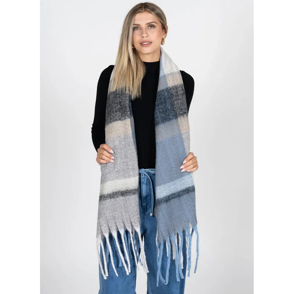 C&#39;est Moi Stripe Pattern Blanket Scarf worn by model; grey, beige, blue with fringe, 100% polyester.