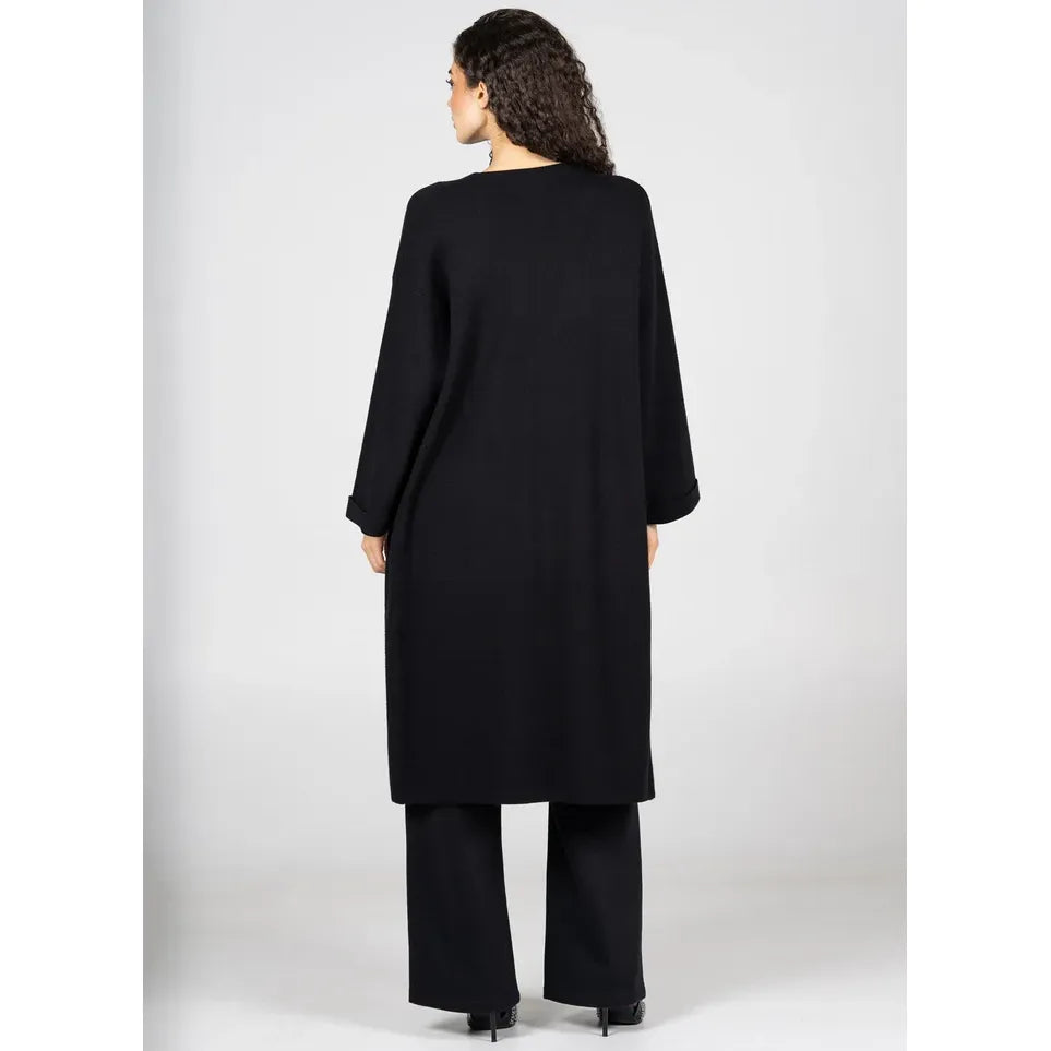 Back view of a model in black C'est Moi Viscose Blend Long Knit Cardigan with a long silhouette and fold-over sleeves.