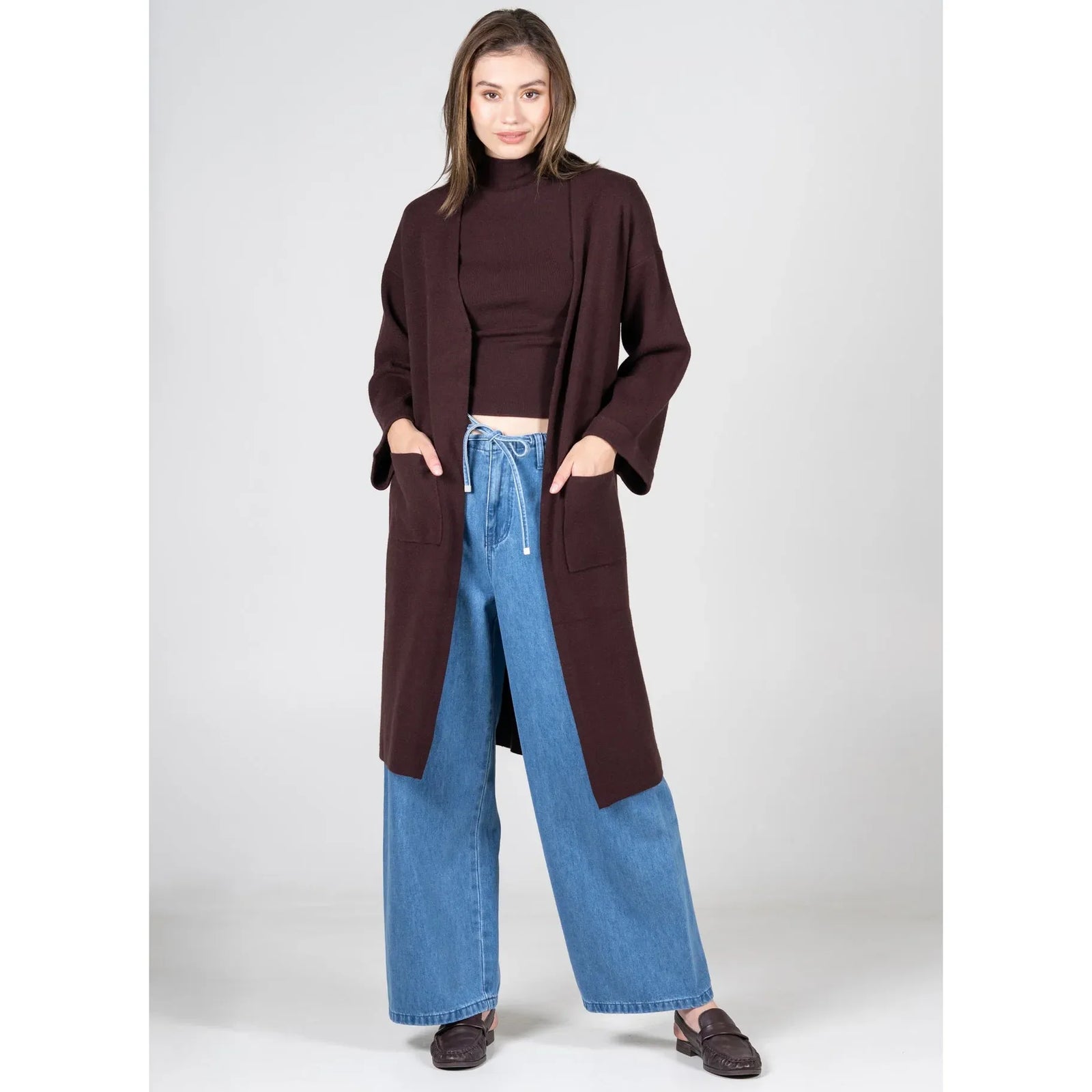 C'est Moi Viscose Blend Long Knit Cardigan, black long silhouette with clasp front and fold-over sleeves over teal top.