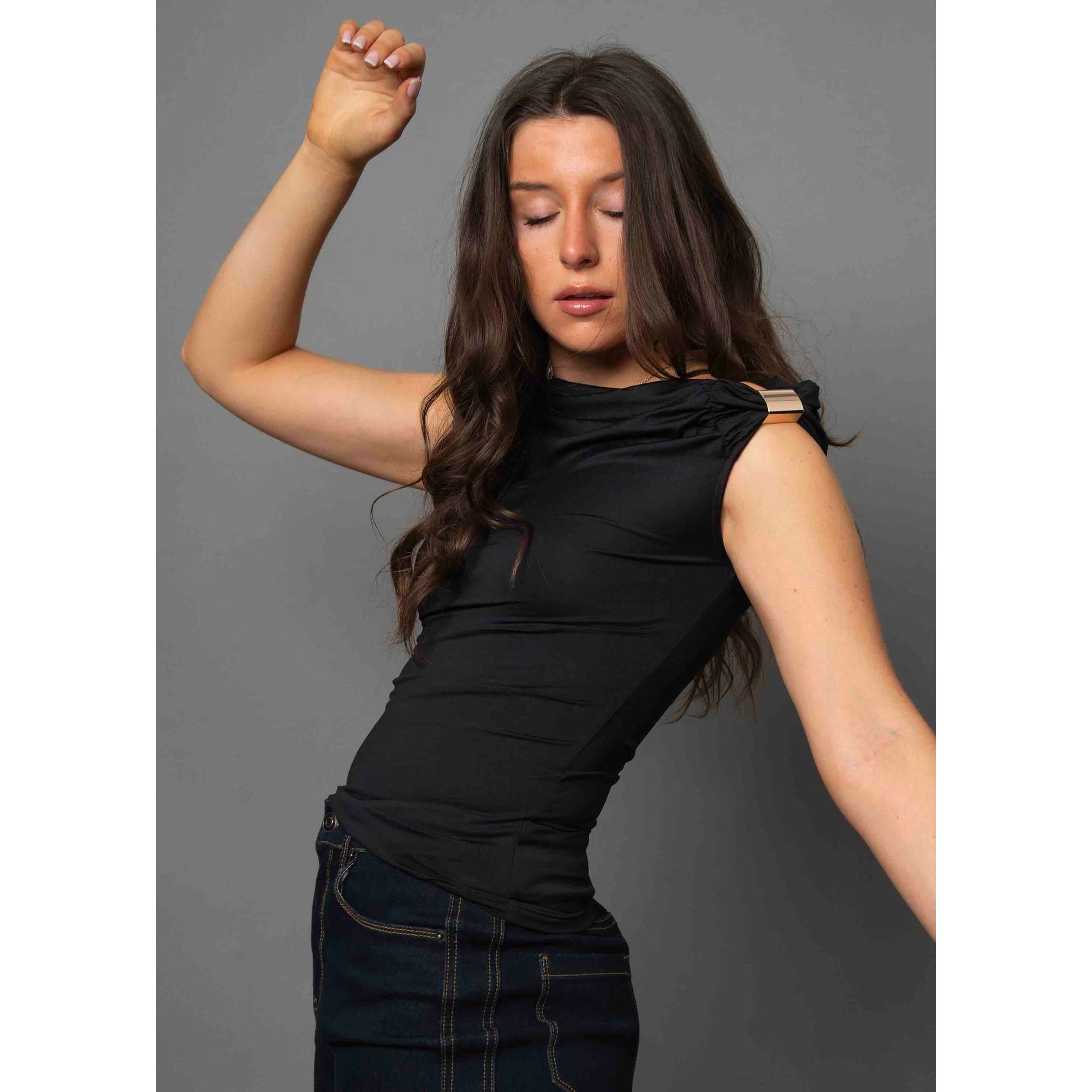 Damian Asymmetric Top on a model: black sleeveless one-shoulder top with gold hardware, versatile from casual to chic.