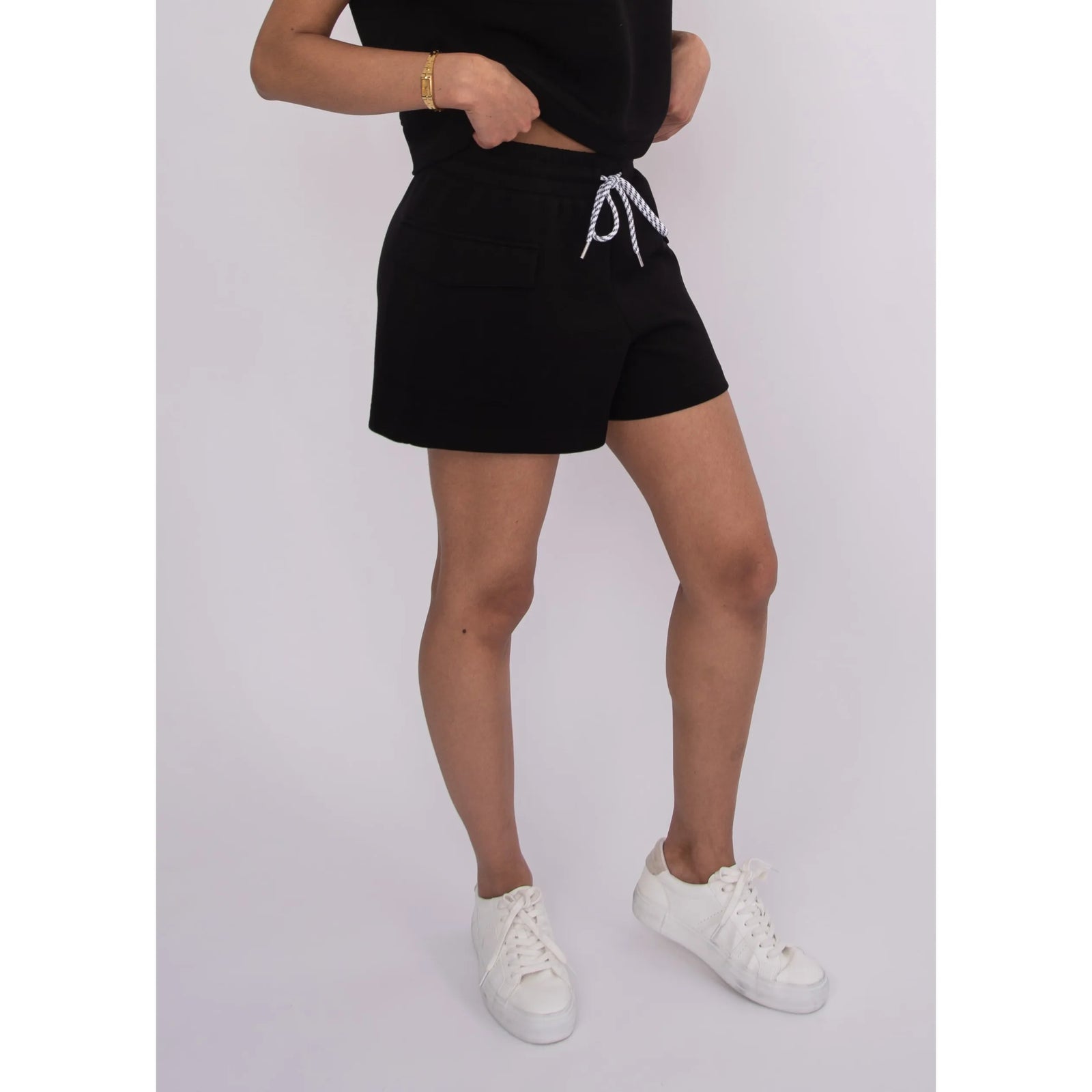 Darcia Soft Knit Drawstring Shorts in black on a model, paired with white sneakers.