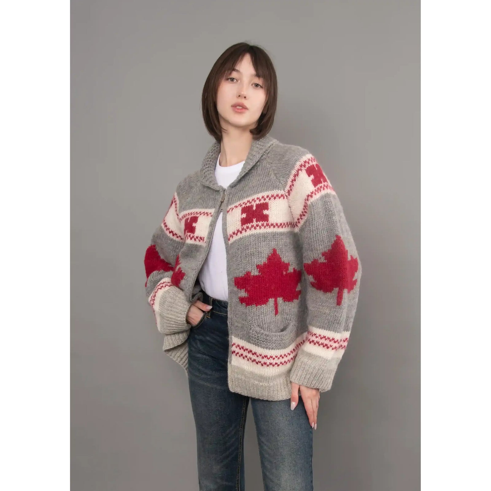 Gray knit cardigan with red maple leaf pattern, shawl collar, and zip front. Cozy longline sweater with sporty raglan sleeves for cold weather.