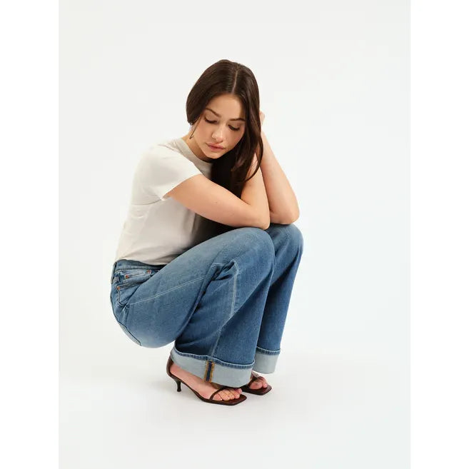 Model wearing Daze Far Out High Rise Wide Leg jeans in Big Break, white tee, rolled cuffs, crouching