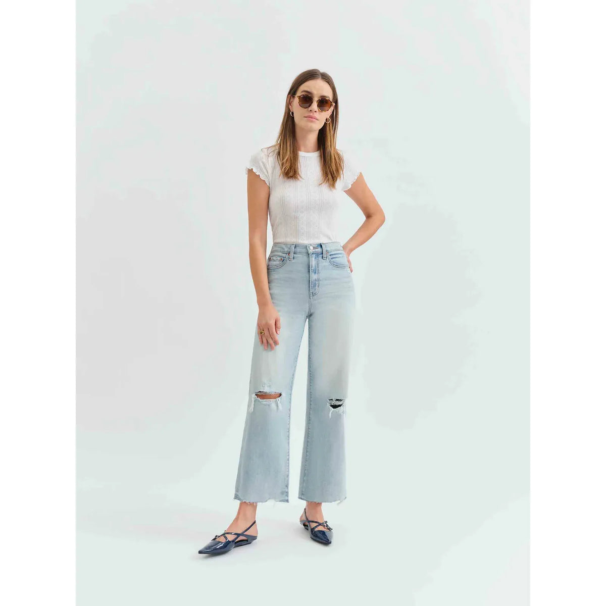 Stylish woman wearing Daze Pleaser High Rise Wide Leg Ankle in Charisma, featuring distressed details and a vintage wash.