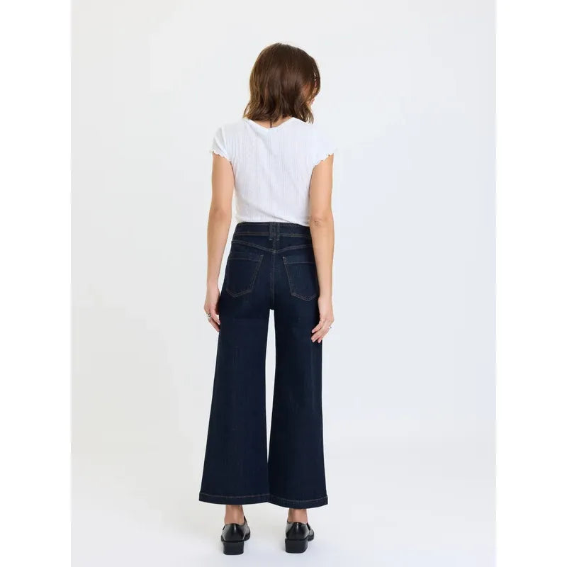 Back view of dark indigo high-rise wide leg ankle jeans featuring vintage-inspired back patch pockets and a deep rinse wash.