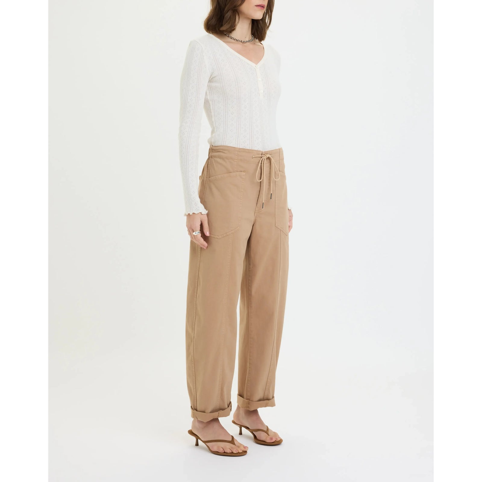 Model wearing Daze Villa Drawstring Barrel Pant in Latte with a white knit top; drawstring waist, tapered silhouette.