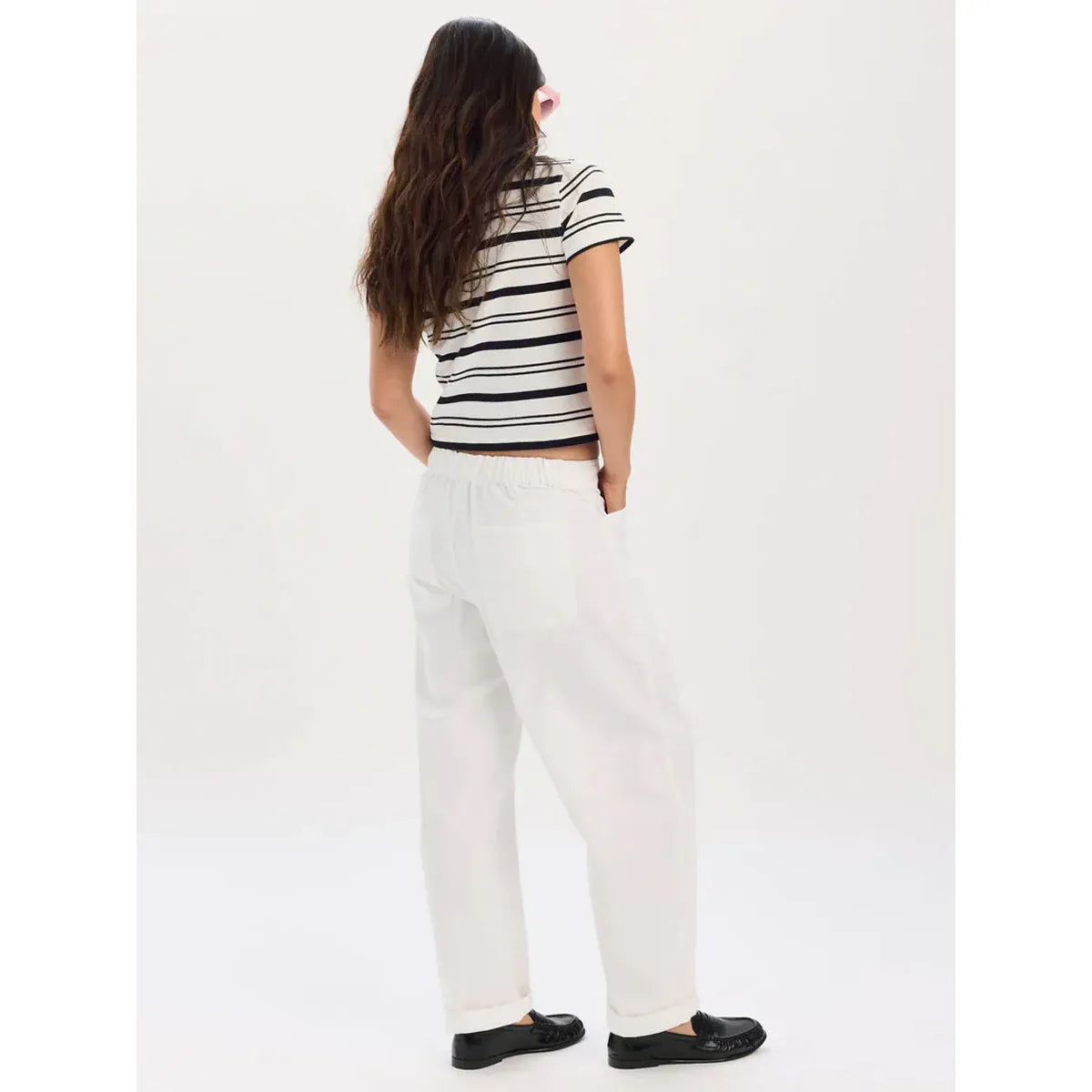 Daze Villa Drawstring Barrel Pant in Lamb: back view of model in white tapered pants with drawstring waist
