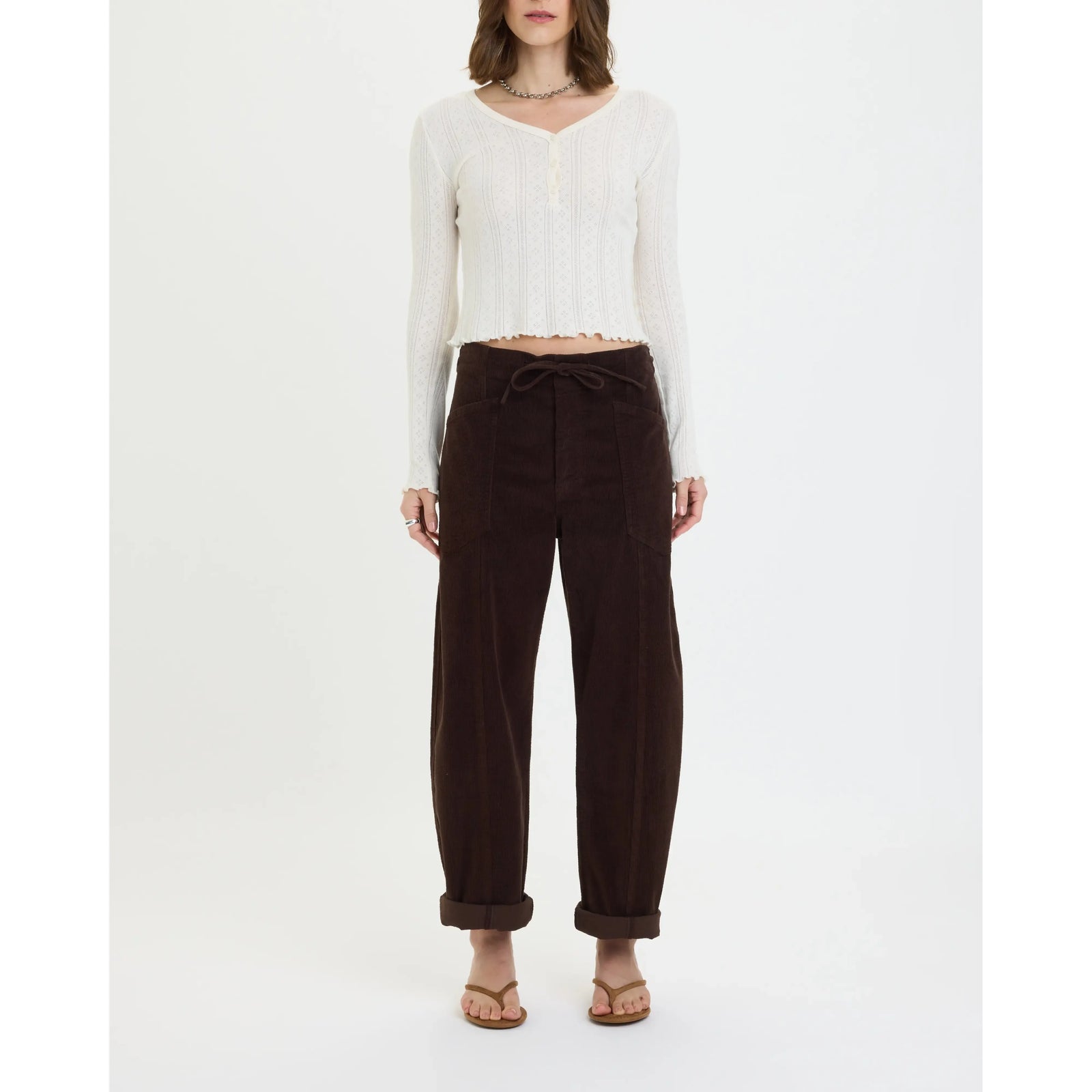 Chocolate corduroy drawstring barrel pants with a relaxed fit, large front pockets, and cuffed ankles for casual comfort.