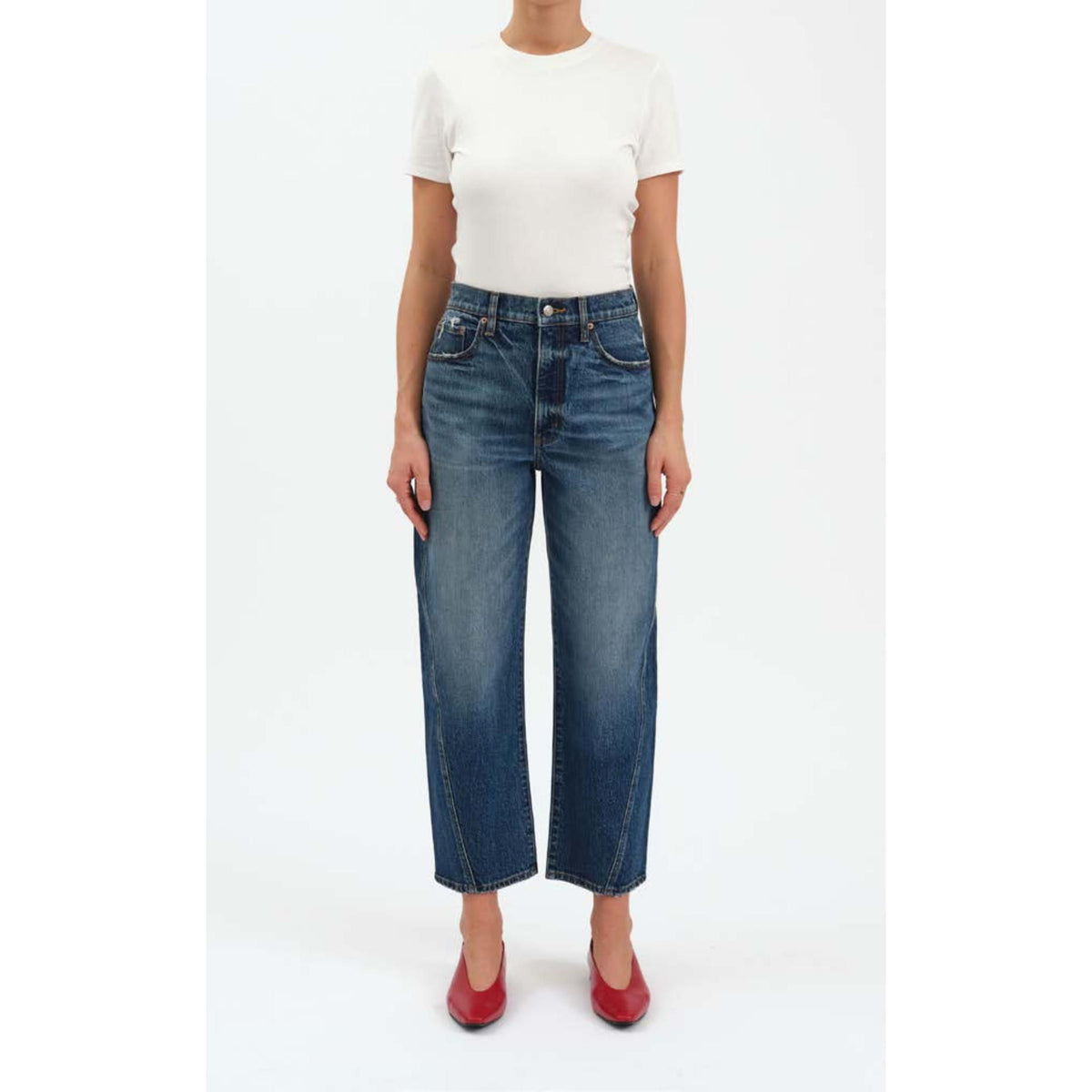 High-rise dark indigo barrel leg jeans with a cinched waist, structural bowed leg, and slightly tapered ankle.