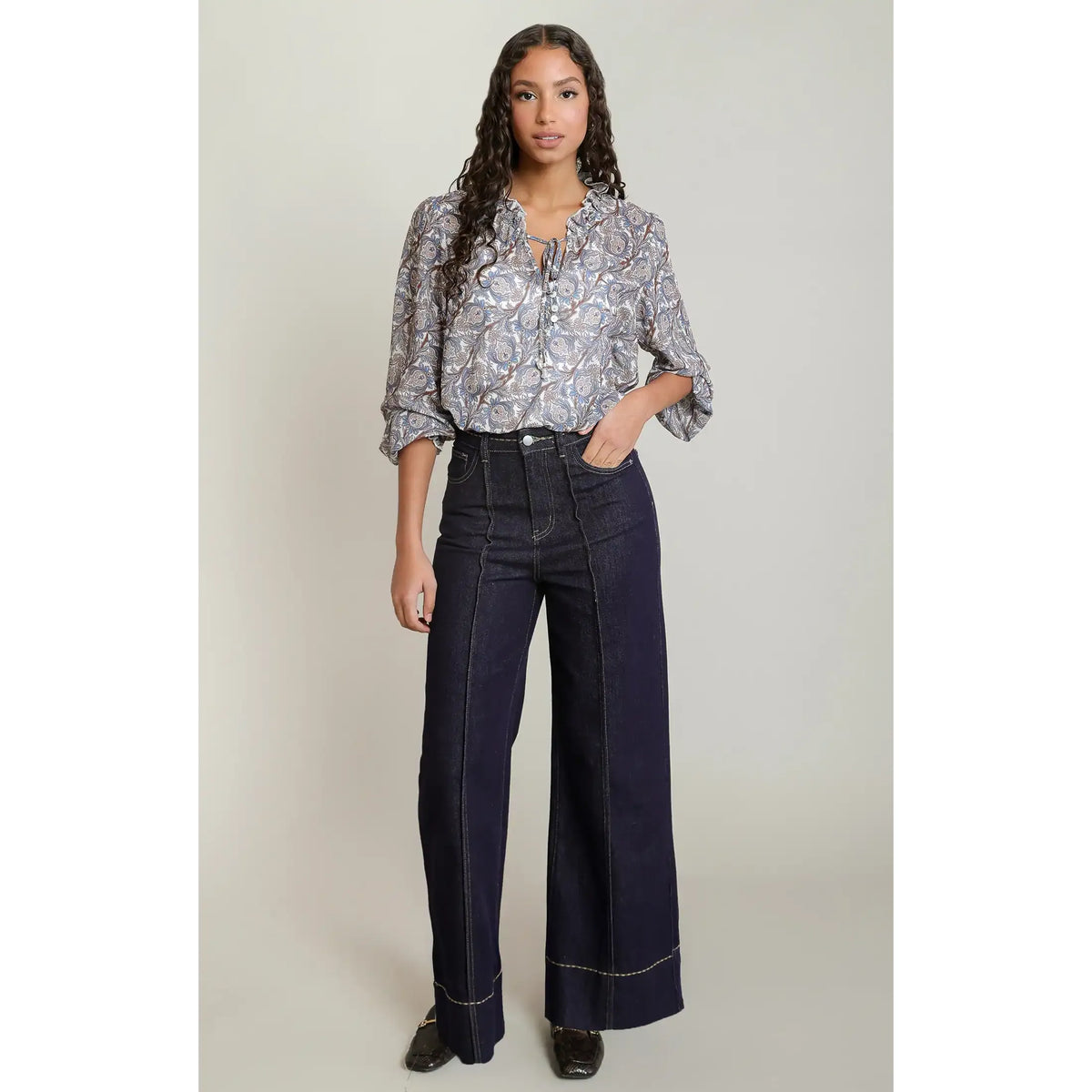Paisley printed balloon sleeve blouse with V-neck tie detail styled with dark wide-leg jeans.