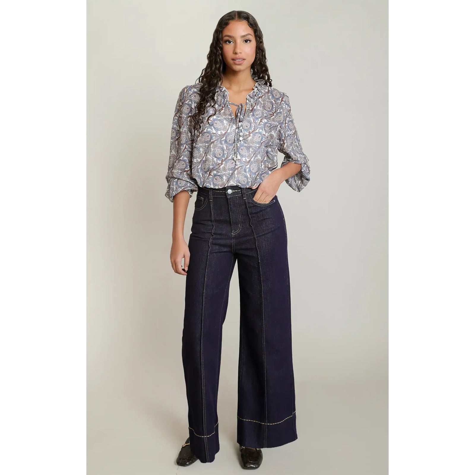 Paisley printed balloon sleeve blouse with V-neck tie detail styled with dark wide-leg jeans.