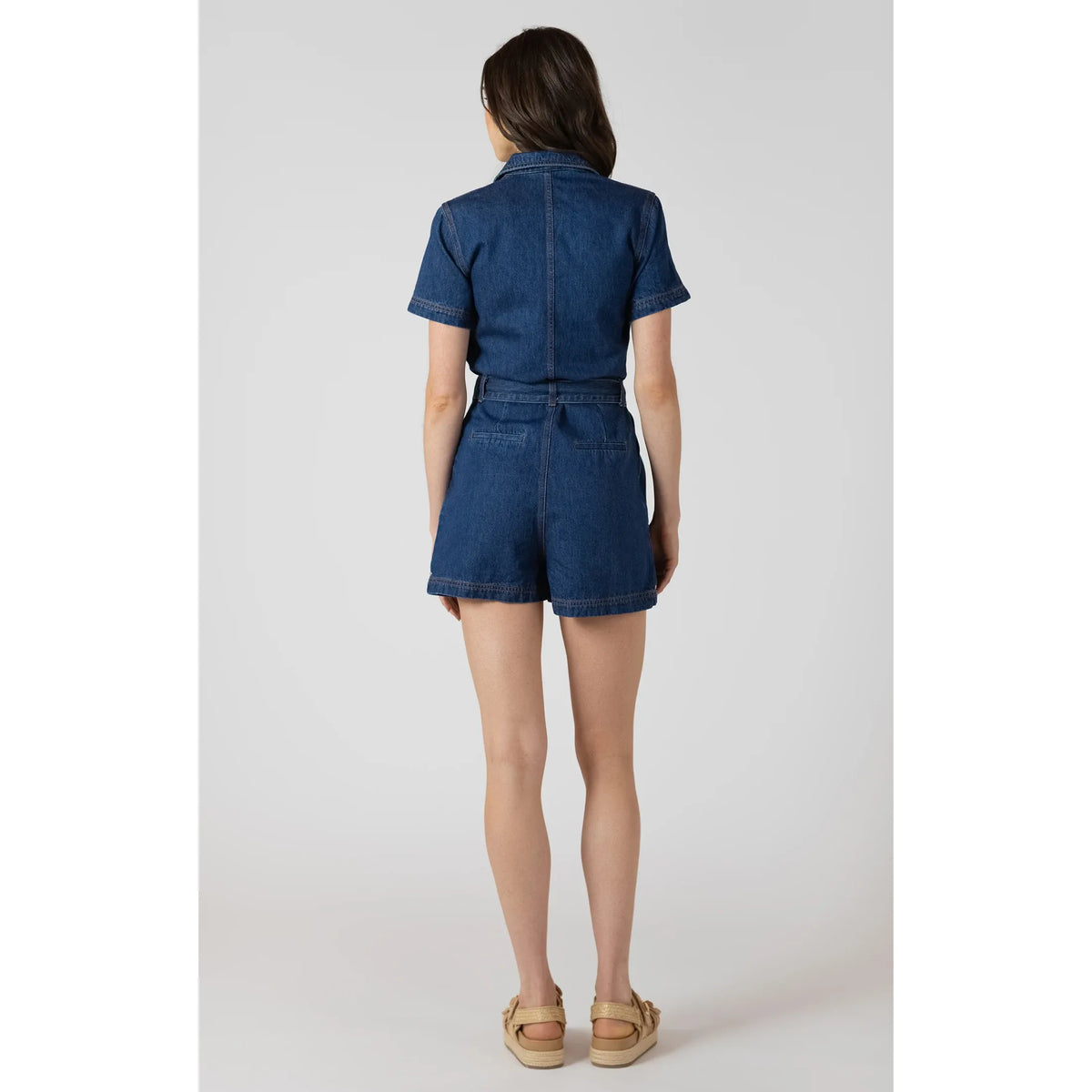 Dex Belted Utility Romper in medium indigo denim, back view with waist belt and back pockets.
