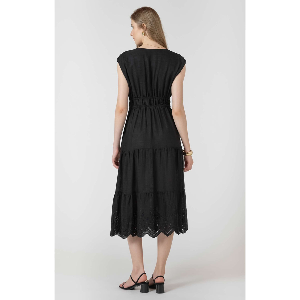 Dex Black Tape Eyelet Dress shown from back: black-wash woven midi with elastic waist, tape eyelets and tiered hem.