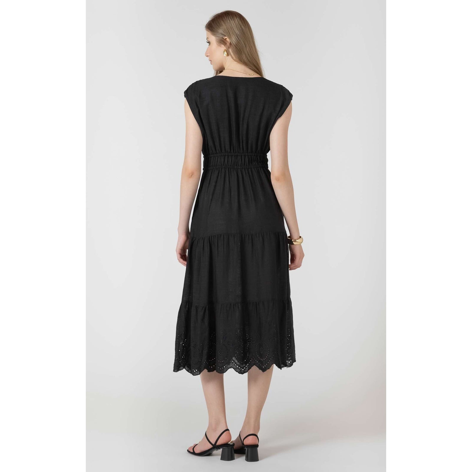 Dex Black Tape Eyelet Dress shown from back: black-wash woven midi with elastic waist, tape eyelets and tiered hem.