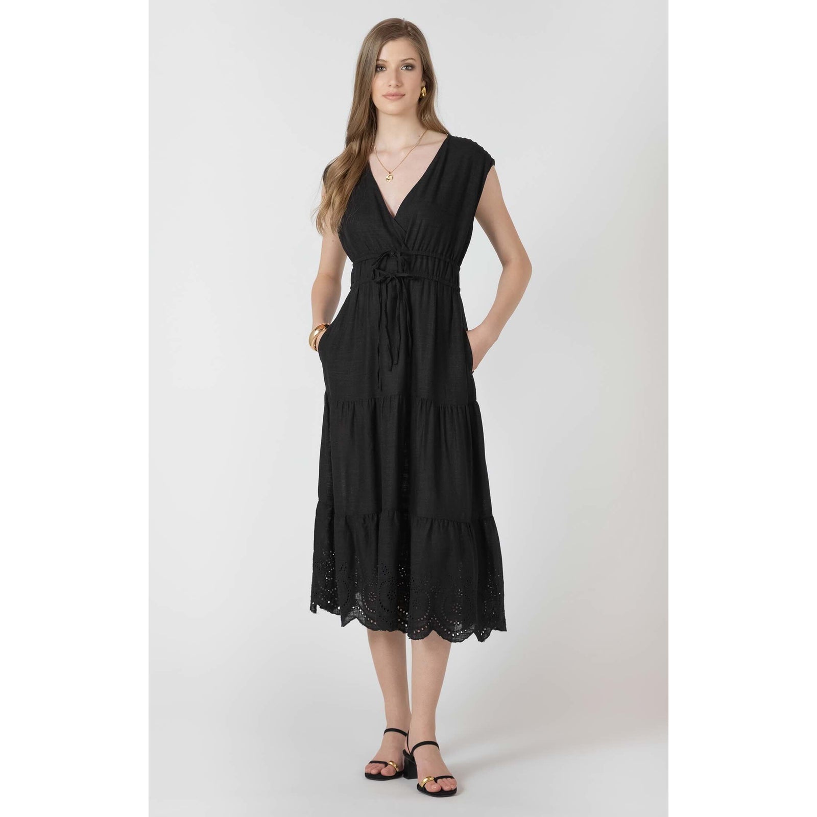 Dex Black Tape Eyelet Dress on a model: black midi with V-neck wrap, tie waist, tiered skirt, eyelet lace hem.