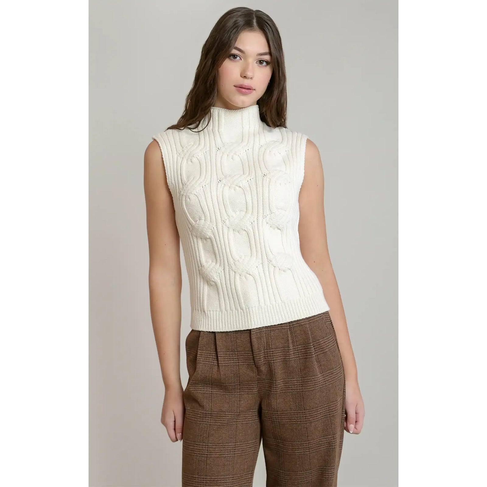 Cream cable knit sweater vest with a mock neck, featuring textured knitting for sophisticated fall layering.