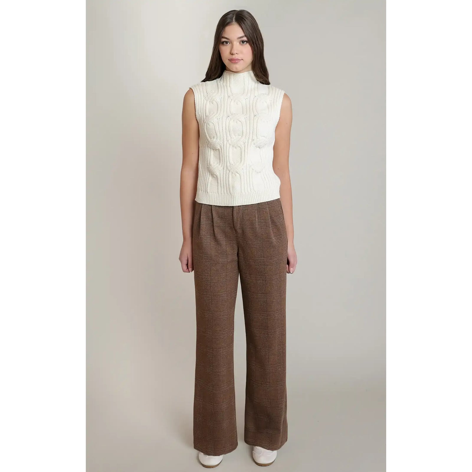 Cream cable knit sweater vest with a mock neck, featuring textured knitting for sophisticated fall layering.