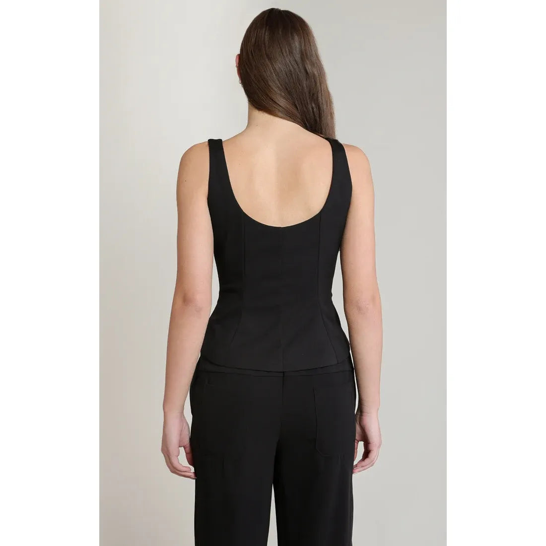Back view of a black embellished peplum top featuring a wide scoop neckline, structured waist, and flattering flared silhouette.