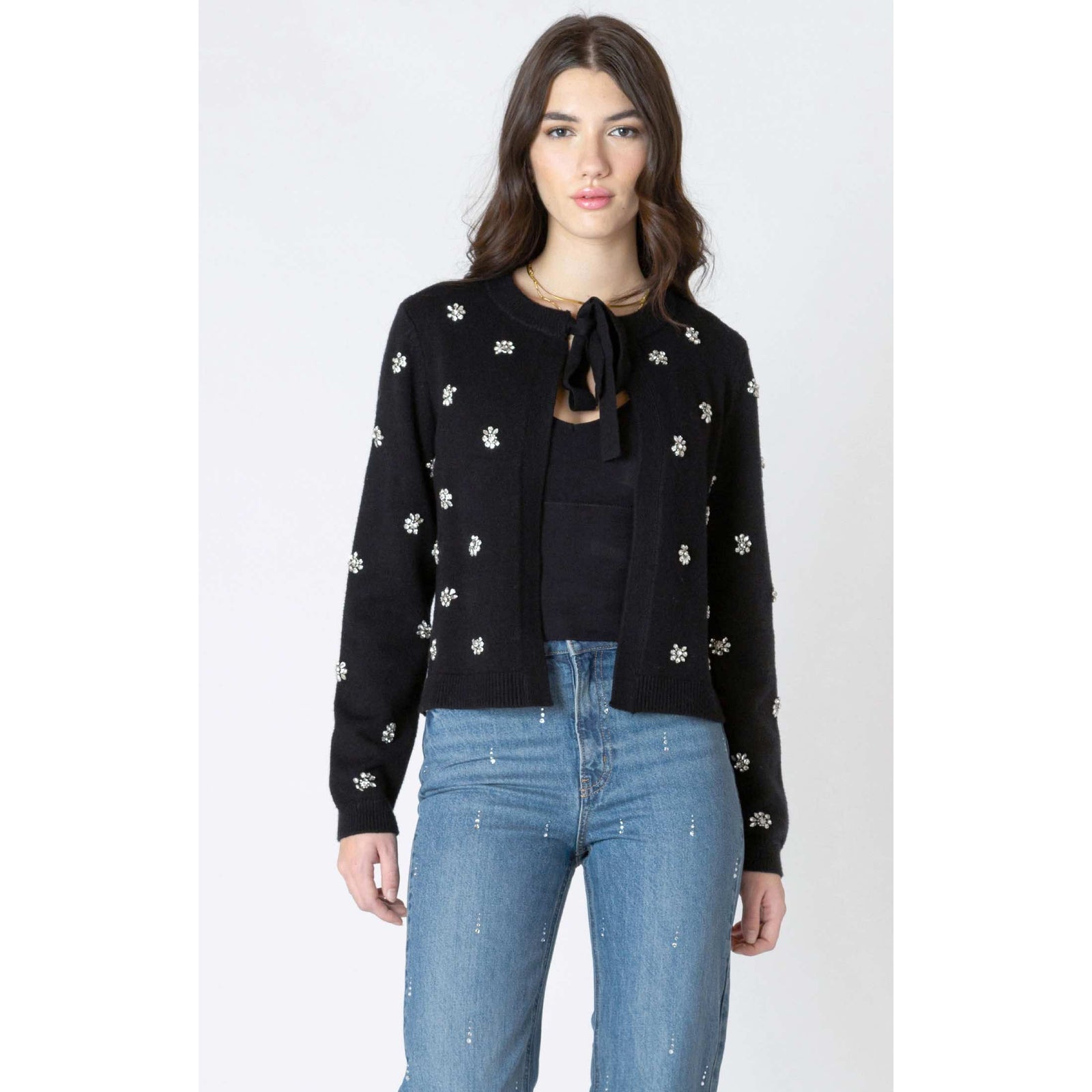 Model wearing Dex Embellished Tie Front Cardigan: black knit with floral embellishments and tie-front detail.
