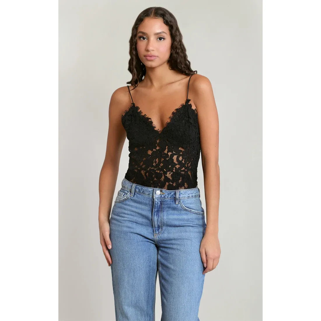 Black lace camisole top with delicate embroidery detail and thin straps, styled with blue jeans for everyday layering.