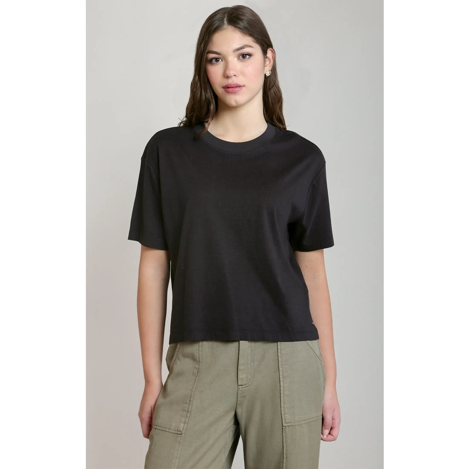 Black short sleeve essential tee with a relaxed fit and round neck, styled with olive cargo pants.