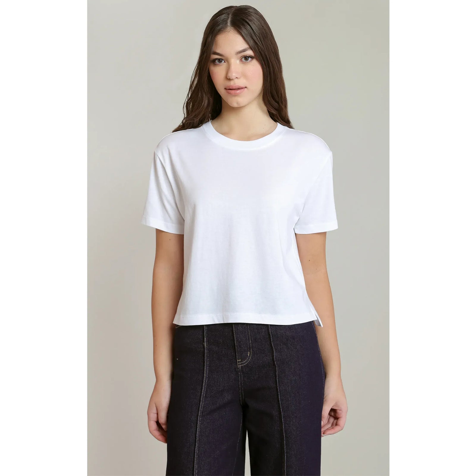 Brown short-sleeved essential tee with a relaxed fit and round neck, styled here with dark denim jeans.