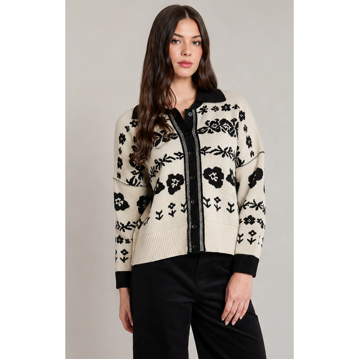 Ivory cardigan with bold black floral jacquard pattern, black trim, and collar. Cozy graphic knit sweater.