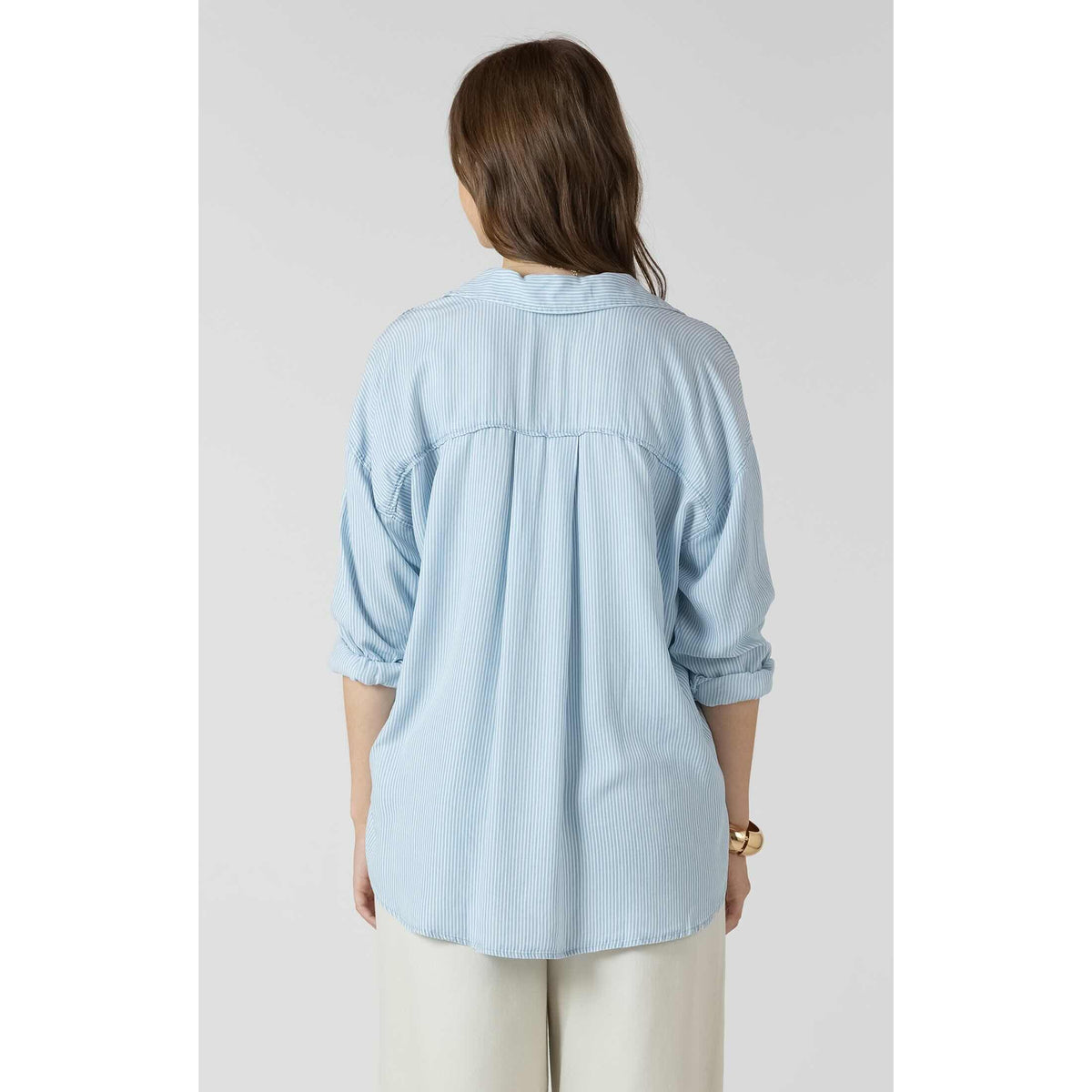 Dex Relaxed Button Front Shirt in light blue pinstripes, back view with pleated yoke and rolled sleeves.
