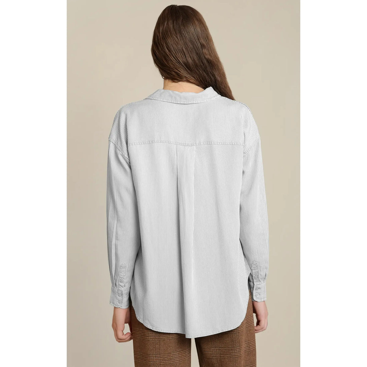 Back view of a relaxed taupe button front shirt with white stripe detailing, center pleat, and soft Tencel drape.