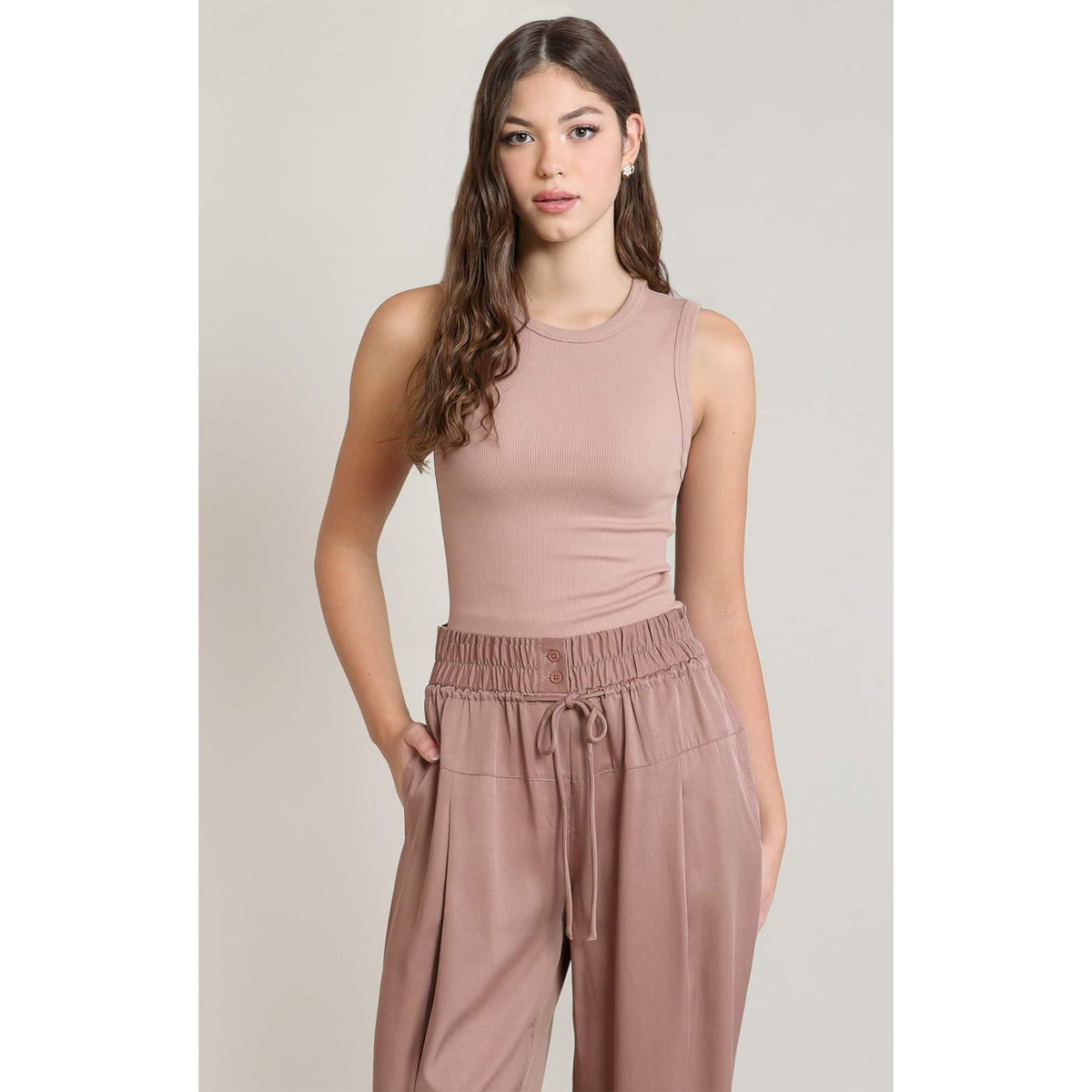 Dex Ribbed Tank in soft pink ribbed knit on a model; sleeveless top with a sleek silhouette.