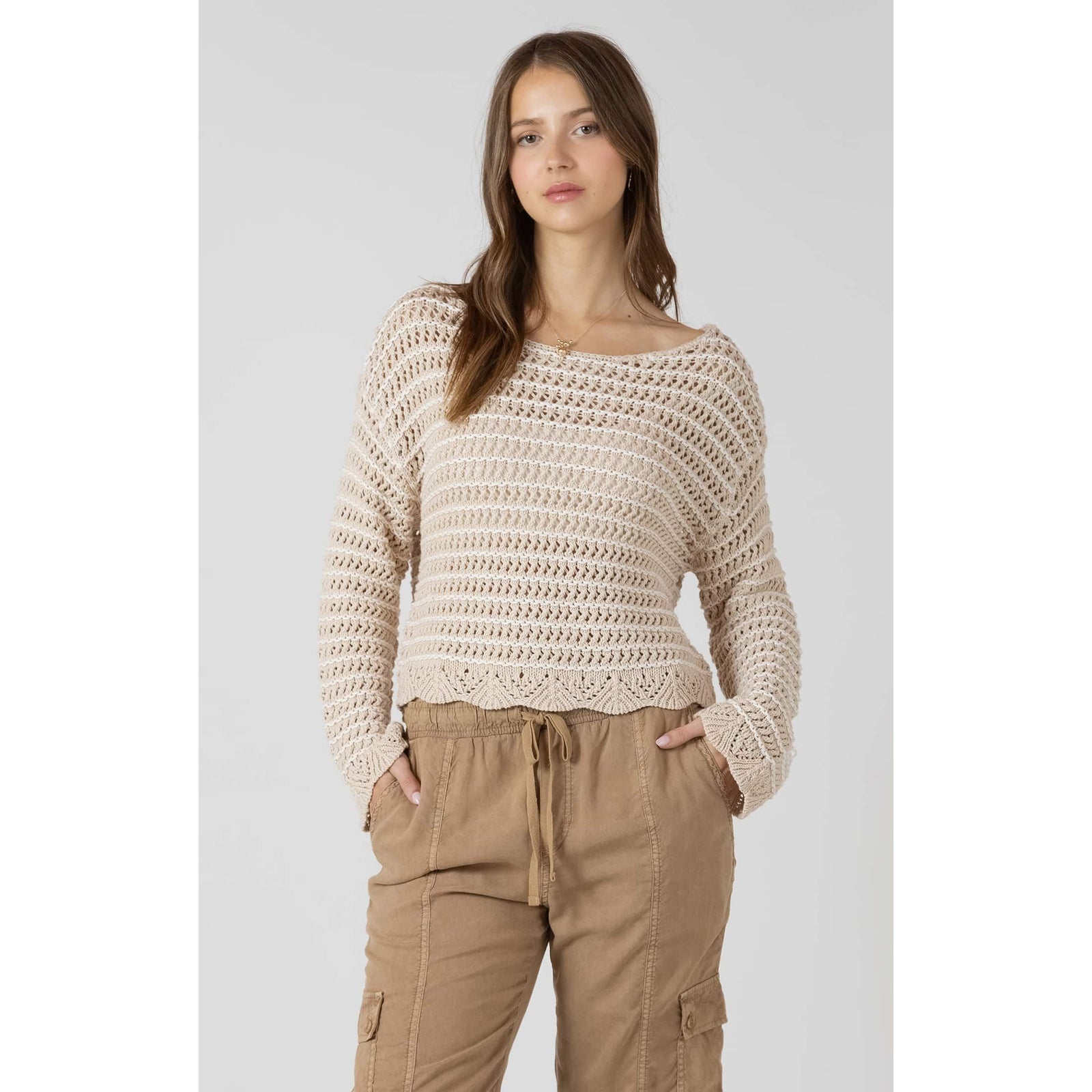 Dex Open Stitch Scalloped Hem Sweater on a model in beige open-knit with a scalloped hem, long sleeves, tan pants.