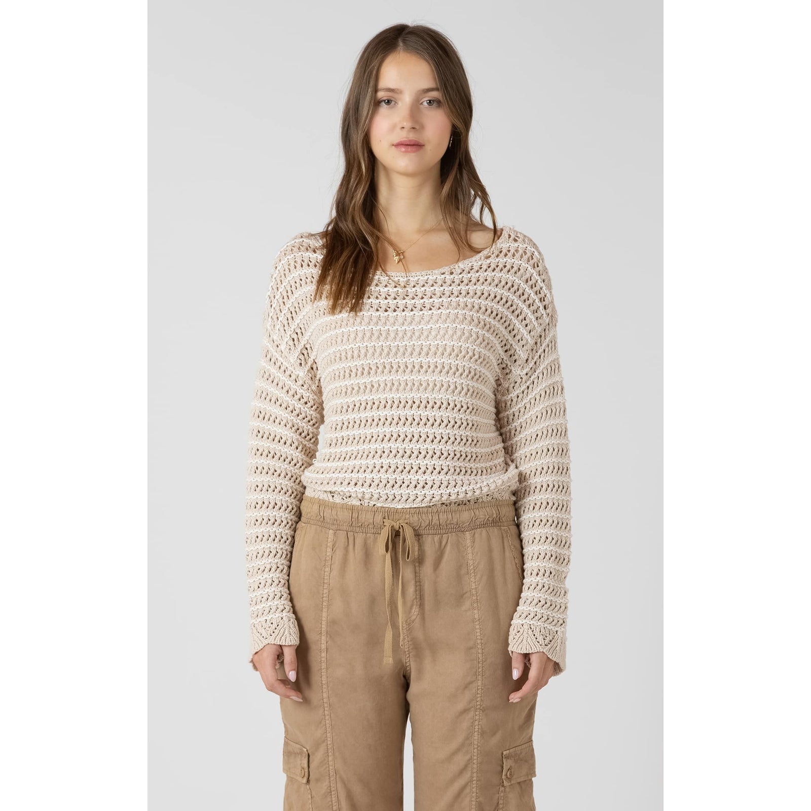 Model wearing a cream Dex Open Stitch Scalloped Hem Sweater; lightweight open-knit with long sleeves and scalloped hem.