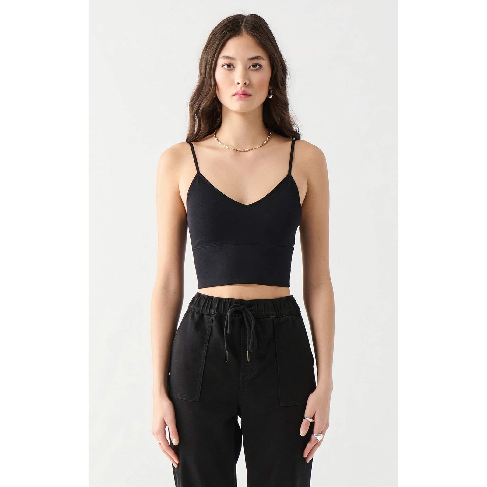 Dex Seamless Bra Top in black on a model; soft cotton-spandex blend, seamless cropped silhouette with thin straps.